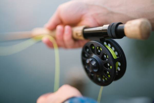 Best fly fishing rod under $100. Holding fly rod and fly line.